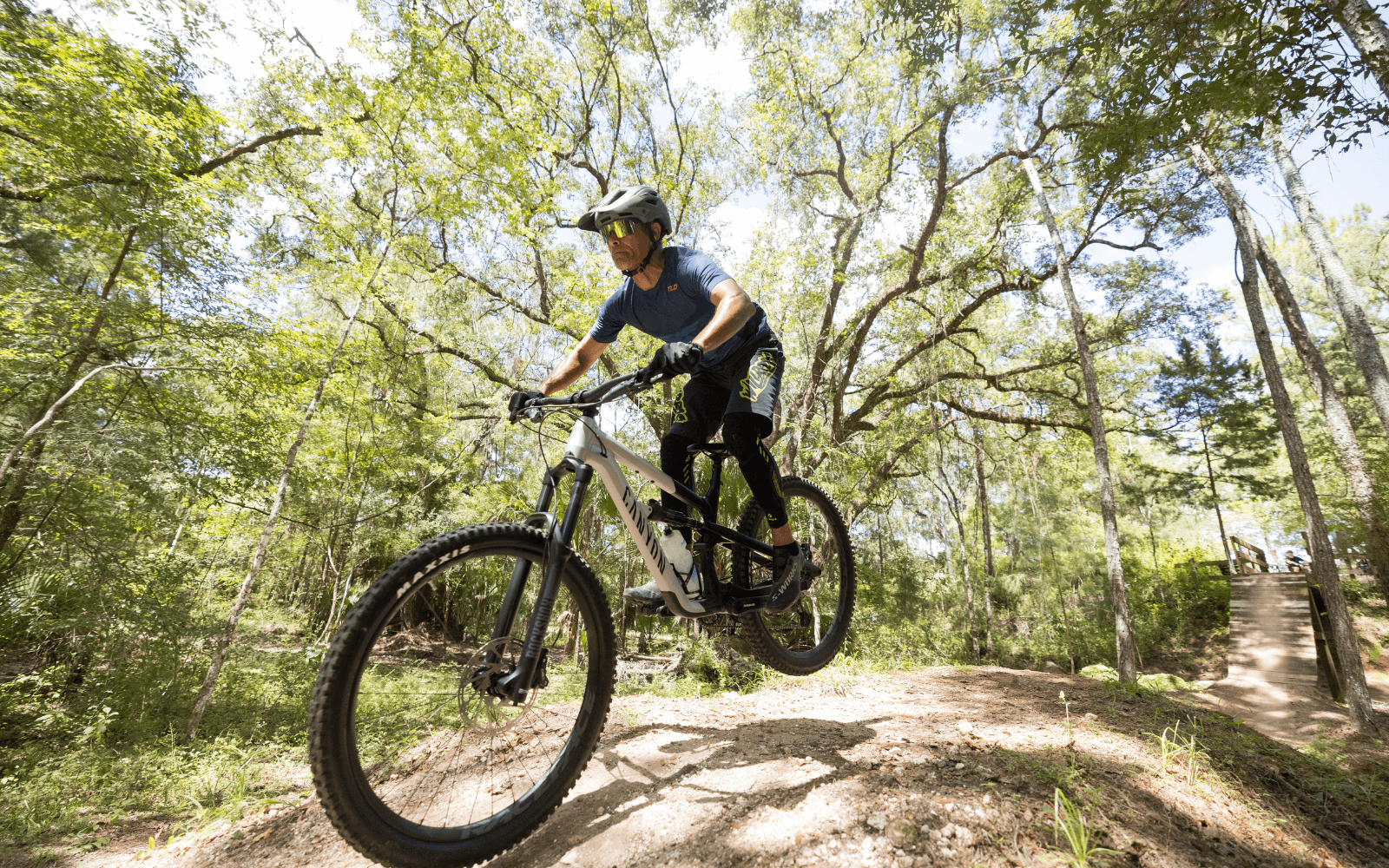 Mountain biker riding technical Florida terrain with dynamic trail action